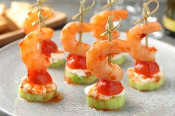 Tasty canapes with shrimps, vegetables and cream cheese on table, closeup