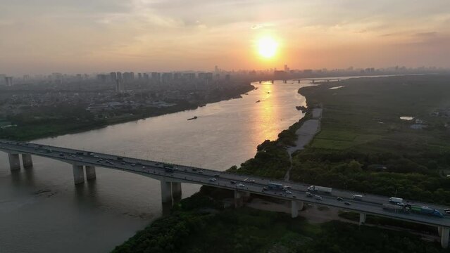 Aerial drone skyline video of Hanoi cityscape at sunset with Vinh Tuy bridge