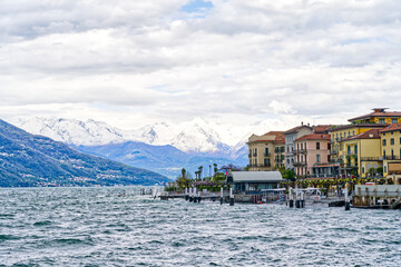Lake Como village Bellagio ferry station background snowy mountains in Italy, Europe