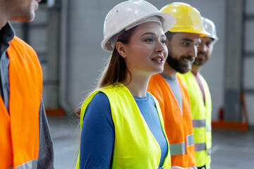 Happy engineers, smiling female worker wearing protective helmets talking with colleagues