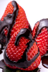 Close-up of ripe strawberries covered in melted chocolate. White background - 786293510