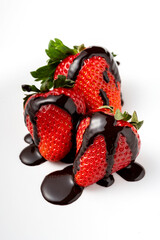 Close-up of ripe strawberries covered in melted chocolate. White background