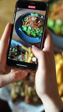 takes vertical video of food on phone