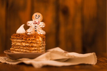 Obraz na płótnie Canvas Peace of delicious homemade Christmas cake decorated with gingerbread man and marshmallows