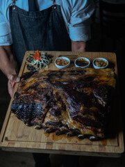 person holding a tray with grilled cow ribs 