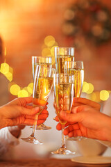 Champagne glasses in hands on golden background