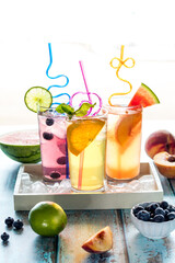 Refreshing fruit flavoured spritzer waters in a tray of ice, surrounded by fruit