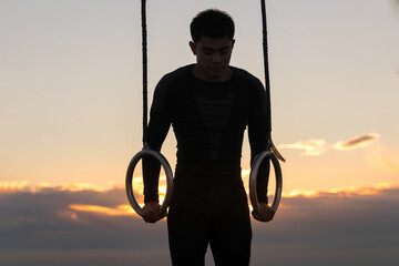 Silhouette of asian man training outside fitness park