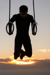 Silhouette of asian man training outside fitness park