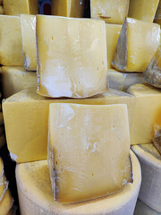 Delicious yellow cheese, cut into chunks, on the shop window