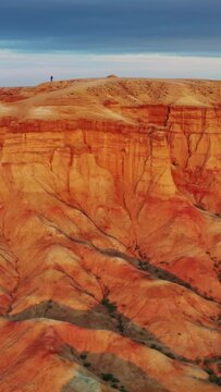 Aerial around view of textural colorful striped canyons Tsagaan suvarga - White stupa at sunrise. Ulziit soum, Dundgovi province, Mongolia. Vertical video