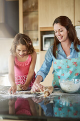 Mother, child and baking dough in kitchen or learning support for breakfast, bread or bonding. Woman, daughter and flour on counter or teaching girl in home for homemade cookies, dessert or happiness