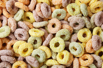 Tasty cereal rings as background, top view