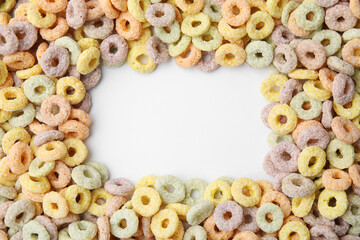 Frame made of tasty cereal rings on white background, top view. Space for text