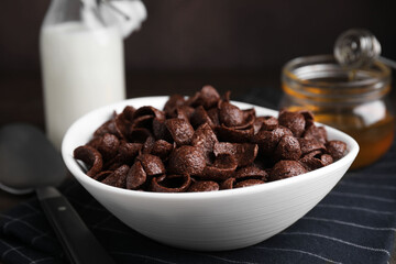 Breakfast cereal. Chocolate corn flakes in bowl on table, closeup