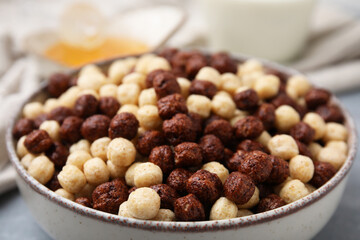 Tasty cereal balls in bowl on table, closeup