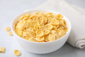 Breakfast cereal. Tasty corn flakes with milk in bowl on white table, closeup