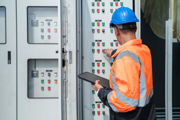 Technician Operating Control Panel in Industrial Setting