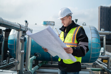 Engineer Analyzing Blueprints at Industrial Pipeline Site