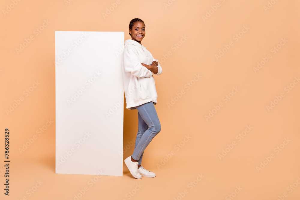 Wall mural Full size profile photo of attractive positive girl folded arms empty space poster isolated on beige color background