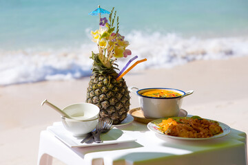 Asian beach still life with fresh exotic cocktail in pineapple decorated tropical flowers. Thai Tom...