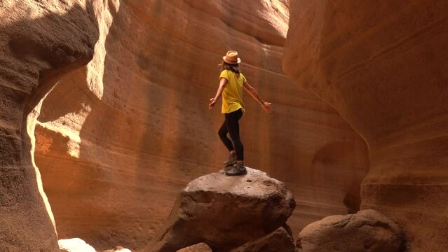 A woman in a yellow t-shirt in the limestone canyon Barranco de las Vacas in Gran Canaria, Canary Islands