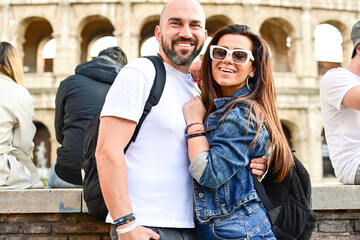 Happy  Beautiful Tourists  couple traveling at Rome, Italy, taking a selfie portrait in front   of Colosseum.Visiting Italy - man and woman enjoying weekend vacation - Happy lifestyle concept 