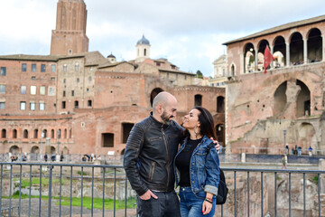 Fototapeta na wymiar Happy Beautiful Tourists couple traveling at Rome, Italy, poses in front of Rpman Forum at, Rome, Italy