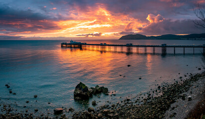 Sunrise over llandudno Pier with the tide in