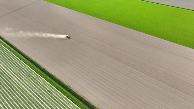 Agricultural transport. Tractor in the field. Working the land. Aerial view of the field. Landscape from a drone. Light and shadow. Natural background from drone. View from above. Agriculture.