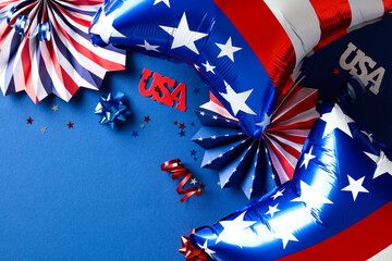 USA Independence Day 4th of July party decorations, balloons, paper fans on dark blue background. Flat lay, top view.