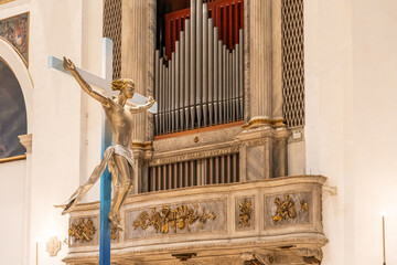 Metal pipe organ and crucifix inside church in Italy