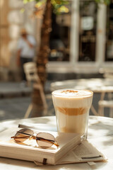 Morning coffee scene with iced latte and sunglasses on table