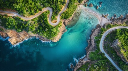 Aerial shot of curvy road on cliffside by clear blue sea