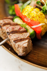 Dutch skewers with corn and cow steak, vegetables and sauce