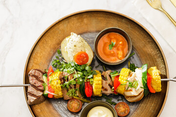 Dutch skewers with corn and cow steak, vegetables and sauce