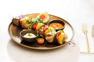 Dutch skewers with corn and cow steak, vegetables and sauce