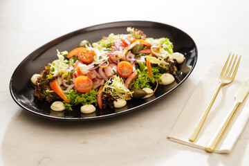 Fresh  Vegetable green salad with sauce on a black plate