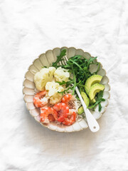 Lunch diet - rice, shrimp, boiled cauliflower, arugula, avocado in one plate on a light background, top view - 786358969