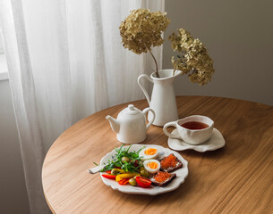 Delicious breakfast, brunch served on a wooden table - fresh salad, boiled egg, red caviar sandwiches and tea - 786359509