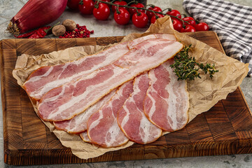 Sliced pork bacon over board