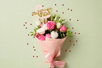 Bouquet of flowers for Mother's Day with confetti on pastel green background, top view