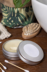 Opened body butter jar near personal care products on wood close up, cosmetic mockup