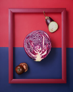 Cabbage, eggplant and tomato in wooden picture frame