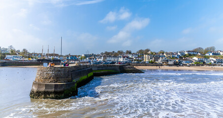 A view towards the harbour wall as the tide turns in the village of Saundersfoot, Wales on a bright...