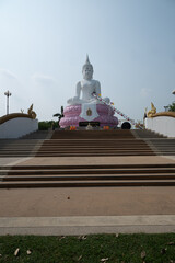 Saraburi, Thailand, April 14, 2024, Pasak Chonlasit Dam White Buddha.. A large white Buddha statue seated on a pink lotus base.