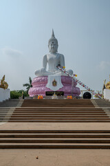 Saraburi, Thailand, April 14, 2024, Pasak Chonlasit Dam White Buddha.. A large white Buddha statue seated on a pink lotus base.