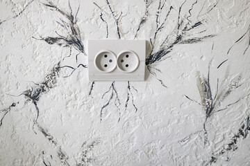 Socket for the electricity on the wall. Beautiful light  background texture with black and grey lines and . Abstract background from plaster on wall around socket