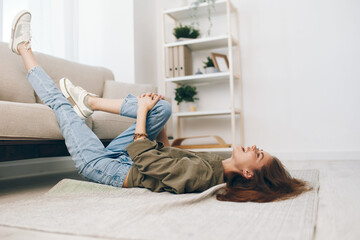 Cosy Apartment: Woman Relaxing on Modern Sofa in Home, Lying on Floor, with a Peaceful Smile -...