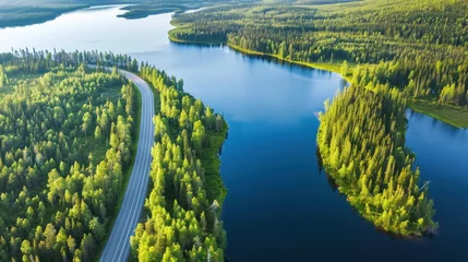 Foto auf Alu-Dibond Beautiful aerial view of road between green summer forest and blue lake in Lapland © Nijat